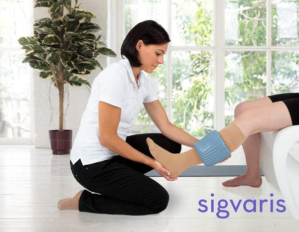 Caregiver assisting patient with compression stockings using Doff N’ Donner sleeve