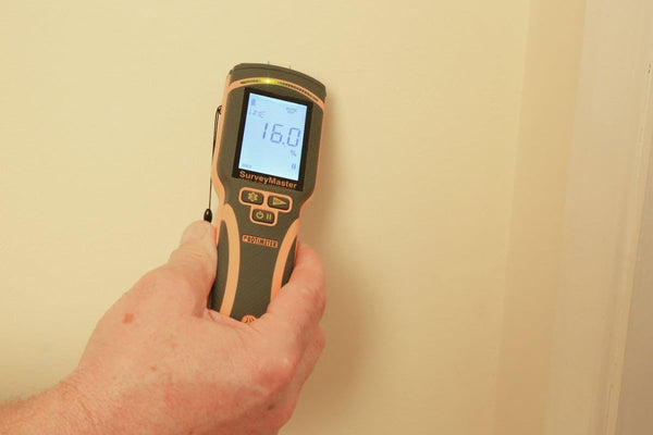 User checking wall moisture levels with Protimeter SurveyMaster moisture meter
