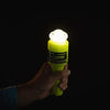 Hand holding ACR ResQFlare electronic distress flare glowing brightly in dark for emergency signaling