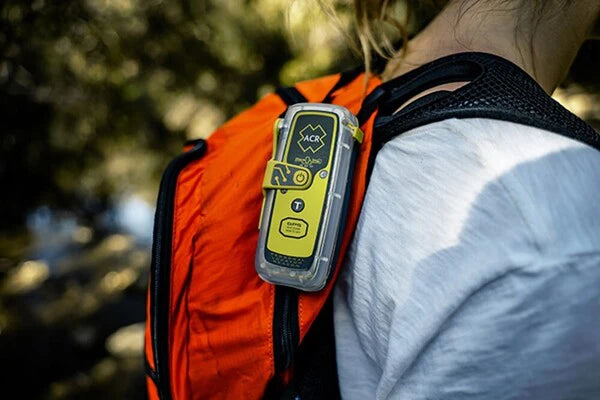 ACR ResQLink 400 personal locator beacon attached to backpack for hiking and outdoor safety use