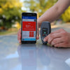 Wireless NexPTG paint thickness gauge with Bluetooth app displaying coating thickness results